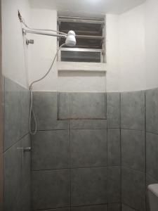 y baño con ducha con cabezal de ducha. en Residencial Barbosa 103, en Macaé