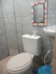 uma casa de banho com um WC branco e um lavatório. em Residencial Barbosa 103 em Macaé