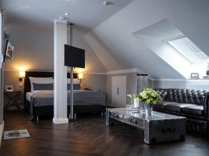 ein Wohnzimmer mit einem Bett und einem Sofa in der Unterkunft Villahotel Rheinblick in Köln