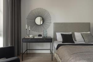 a bedroom with a bed and a table with a mirror at Scala Apartamenty by Moderna Profit- Łąkowa 60G z parkingiem in Gdańsk
