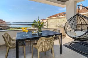 a patio with a table and chairs on a balcony at Luxury Home Polo in Bibinje