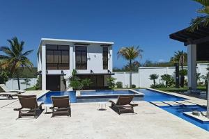 una casa con piscina y algunas sillas en Hacienda Ortiz: Luxury Space., en Matanzas