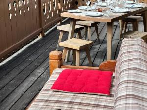 una coperta rossa è appoggiata su una panchina su un tavolo di Chalet Chaleureux à Méribel : Cheminée, Jacuzzi, Proche Commerces, 4 Chambres en Suite - FR-1-688-18 a Méribel Altre 8 foto