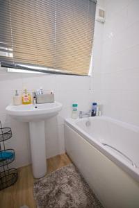 a bathroom with a sink and a bath tub and a sink at Stylish 1-Bed Apartment in Manchester