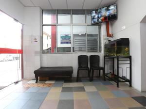 een wachtkamer met twee stoelen en een aquarium bij KB Rest Inn-Twin Single in Kota Bharu