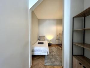 a bedroom with a bed and a lamp in a room at Le Bellifontain - 4 pers - 2 BR in Fontainebleau