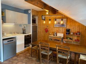 eine Küche mit einem Holztisch und Stühlen im Zimmer in der Unterkunft Appartement Valloire, 3 pièces, 5 personnes - FR-1-263-530 in Valloire