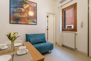 uma sala de estar com uma cadeira azul e uma mesa em Veneziacentopercento Zoto Apartment em Veneza