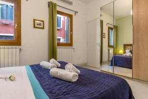 um quarto com toalhas numa cama com um espelho em Veneziacentopercento Zoto Apartment em Veneza