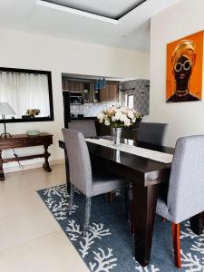 a dining room with a wooden table and chairs at Kaya Apartments 2 in Lusaka