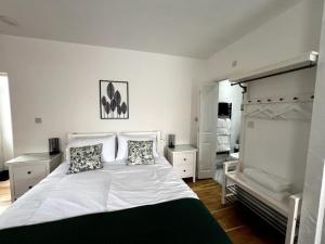 1 dormitorio con 1 cama blanca grande y 2 almohadas en The Grocery Shop en Hathern