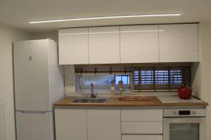 a kitchen with white cabinets and a sink at Orchid Apartments in Thermi