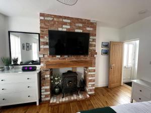 a living room with a fireplace with a television on top at The Grocery Shop in Hathern