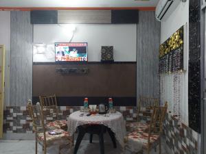 Sanjay resort and hotel في بريلي: غرفة طعام مع طاولة وكراسي وتلفزيون