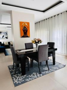 a dining room with a black table and chairs at Kaya Apartments 2 in Lusaka