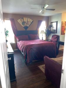 um quarto com uma cama com uma colcha vermelha em Vanessa rooms em Harker Heights