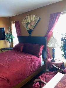 um quarto com uma cama vermelha e uma janela em Vanessa rooms em Harker Heights