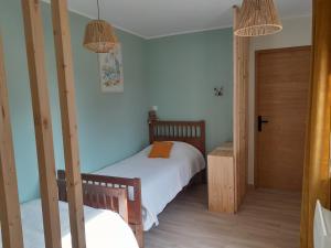 una piccola camera con due letti e una porta di Chez Paulette a Halinghen