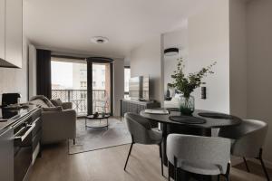 a kitchen and living room with a table and chairs at Scala Apartamenty by Moderna Profit- Łąkowa 60G z parkingiem in Gdańsk