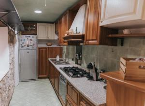 - une cuisine avec des placards en bois et un réfrigérateur blanc dans l'établissement A Casa di Marina, à Bassiano