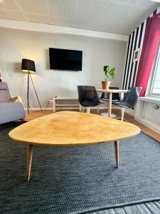 een woonkamer met een salontafel en een televisie bij Appartement lumineux et rénové près de Montmartre "Amélie" in Parijs