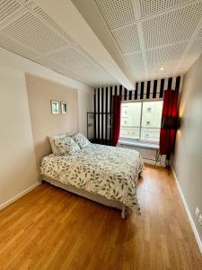 een slaapkamer met een bed en een raam bij Appartement lumineux et rénové près de Montmartre "Amélie" in Parijs