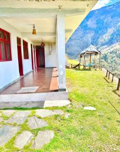 um alpendre de uma casa com vista para uma montanha em Agora Homestay em Uttarkāshi
