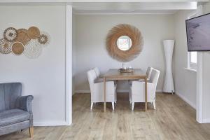a dining room with a table and chairs and a mirror at Techts Sommerhaus in Timmendorfer Strand