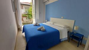 a blue bedroom with a bed with towels on it at Hotel Canarco in Viareggio