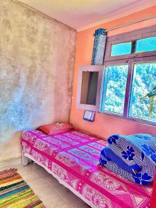 um quarto com uma cama e uma janela em Agora Homestay em Uttarkāshi