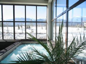un jacuzzi intérieur dans une pièce avec fenêtres dans l'établissement TERRA COMPLEX B4 - Private apartment - Golf, Skiing & SPA, à Bansko