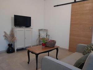 un soggiorno con un tavolo e una tv di Chez Paulette a Halinghen