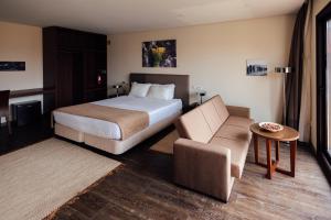 um quarto de hotel com uma cama e uma cadeira em Quinta da Barroca em Armamar