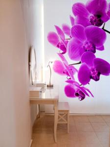 a room with a desk with purple orchids on the wall at Orchid Apartments in Thermi