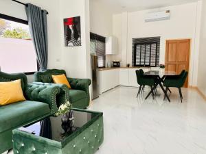 a living room with green couches and a table at Le Trang Boutique Airport in Trang