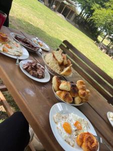 a wooden table with plates of breakfast food on it at EKO KAMP „LUKE“ in Nikšić