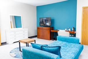 ein Wohnzimmer mit blauen Wänden, einem Sofa und einem Schreibtisch in der Unterkunft Sigelege Boutique Hotel in Lilongwe