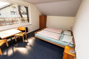 Piccola camera con letto e scrivania. di Baden Youth Hostel a Baden