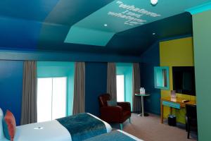 a hotel room with blue walls and a bed and a chair at Skeffington Arms Hotel in Galway