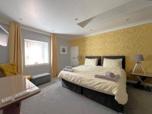 a bedroom with a large bed with two towels on it at Thistle Apartment in Golspie