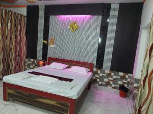 Sanjay resort and hotel في بريلي: غرفة نوم مع سرير مع وسائد وردية عليه