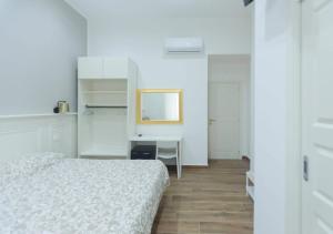 een slaapkamer met een bed en een bureau met een spiegel bij Vomero House in Napels
