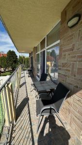 a patio with chairs and tables on a building at Apartman Danka in Bük