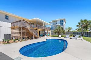 a swimming pool in front of a house at Sav's Beach Pad in Pensacola Beach