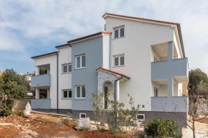 una casa blanca con muchas ventanas en Apartments Mira, en Pula
