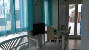 a dining room with a table and chairs and blue walls at Blu Rooms Marettimo in Marettimo