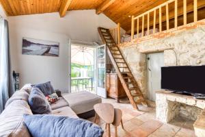 a living room with a couch and a tv at Maison de Campagne in Gignac