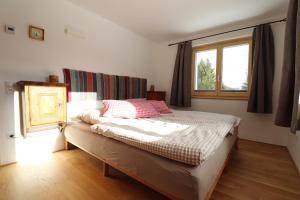 a bedroom with a large bed with a window at Haus Haemmerle mit Ski in - Ski out in Damuls