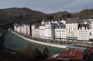 um grupo de edifícios junto a um rio em Appart'hôtel Saint Jean em Lourdes