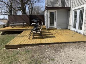 a wooden deck with a picnic table and chairs on it at Cozy Home Lake Huron with Loft 2 Bedroom 1 Bathroom in Au Gres